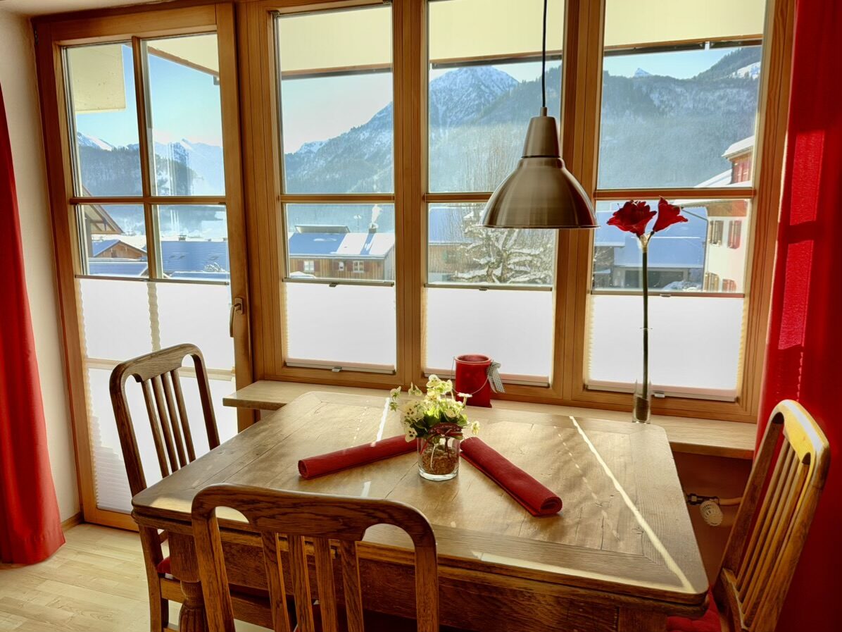 Essplatz am Fenster mit Blick auf die verschneiten Berge